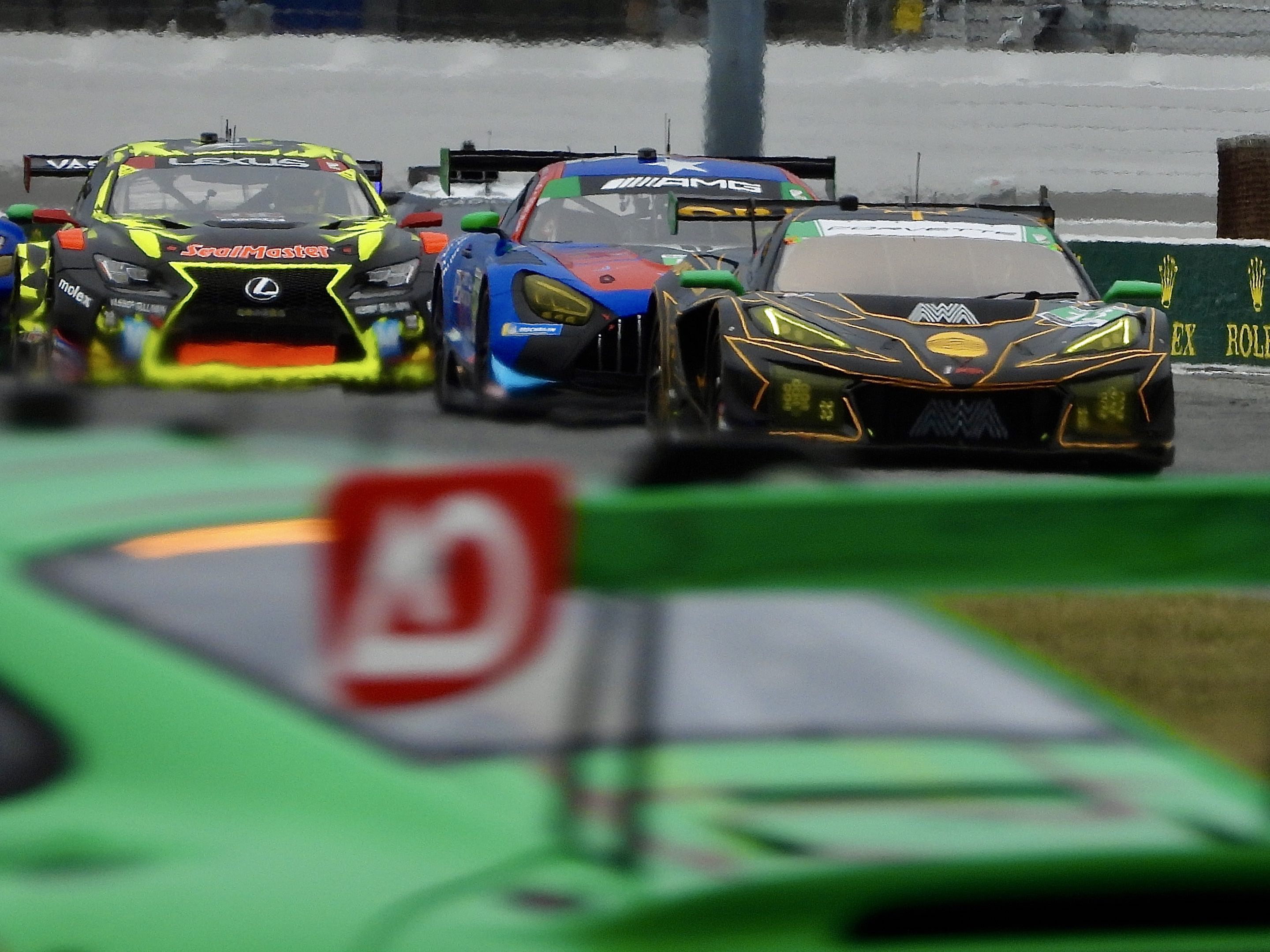 Lexus, Mercedes, Chevrolet, and Porsche GT3 cars making their way around Daytona International Speedway during practice.